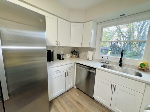 kitchen featuring backsplash, sink, white cabinetry, and stainless steel appliances