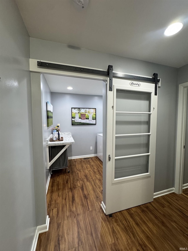 interior space featuring a barn door and dark hardwood / wood-style floors