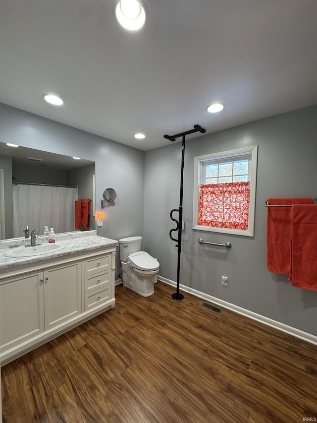 bathroom featuring wood-type flooring, vanity, and toilet