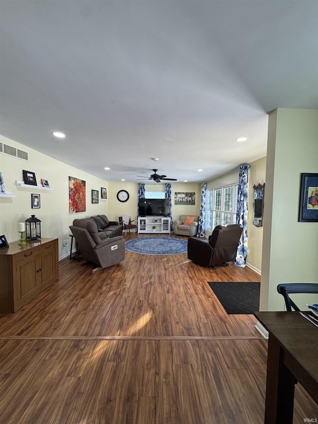 living room with ceiling fan and dark hardwood / wood-style flooring