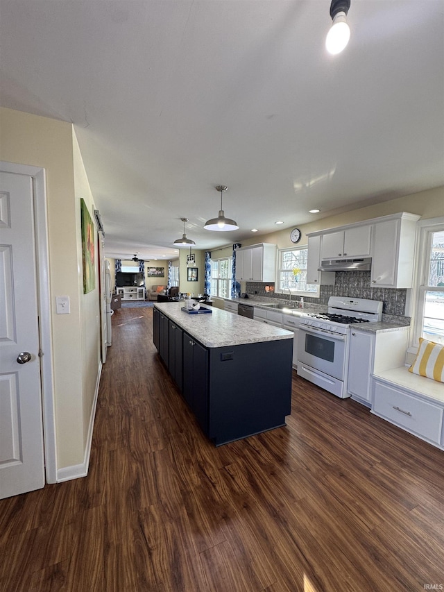 kitchen with white range with gas cooktop, white cabinets, a center island, dark hardwood / wood-style floors, and hanging light fixtures