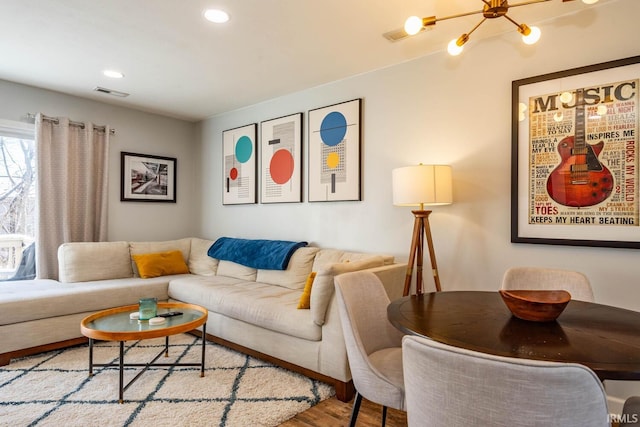 living room featuring a chandelier and light hardwood / wood-style flooring