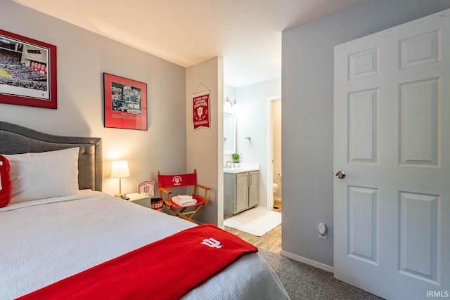 carpeted bedroom featuring ensuite bath