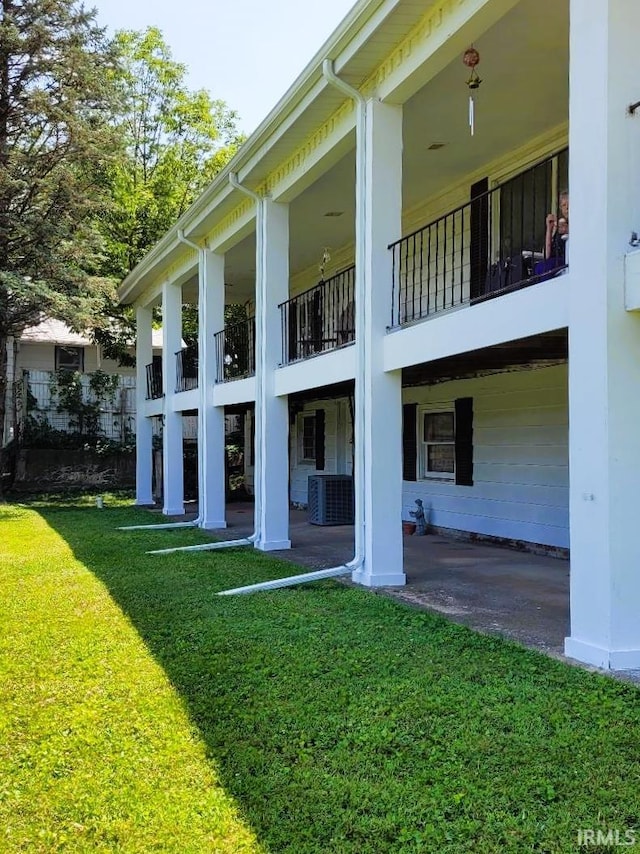 rear view of property featuring a yard and central air condition unit