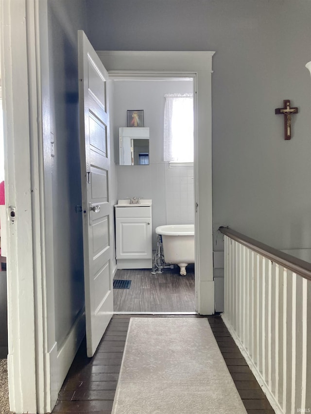 bathroom with hardwood / wood-style flooring, a bathtub, and sink