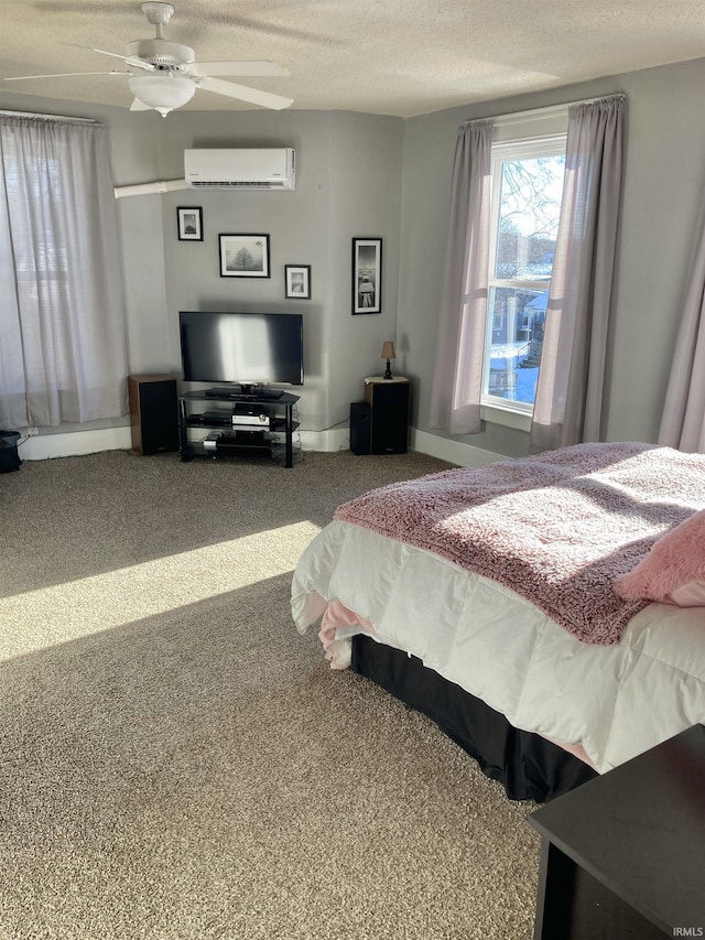 carpeted bedroom featuring ceiling fan, a textured ceiling, and a wall unit AC