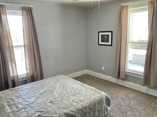 carpeted bedroom featuring multiple windows