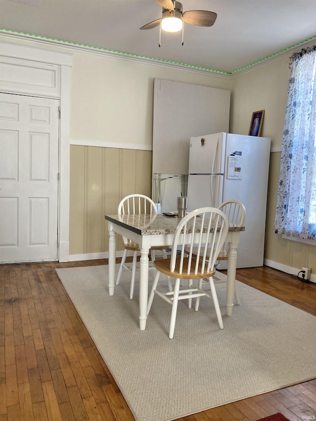 dining room with ceiling fan and dark wood-type flooring