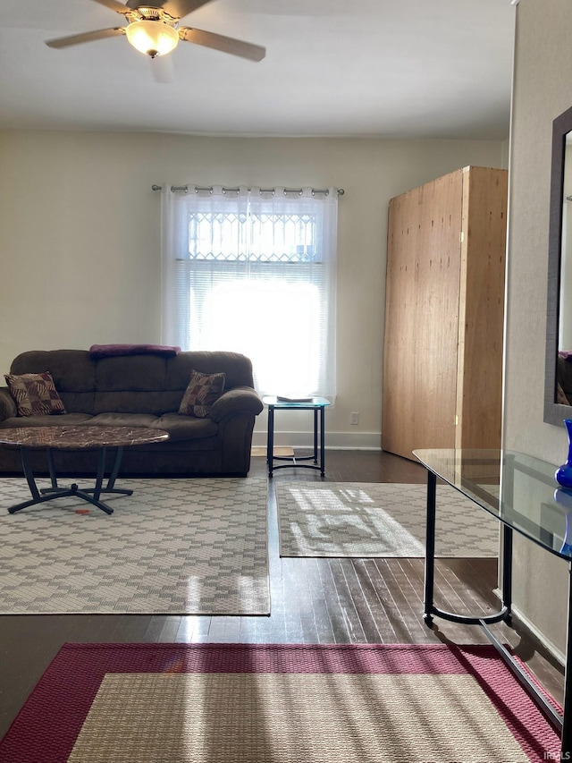 living room featuring ceiling fan and dark wood-type flooring