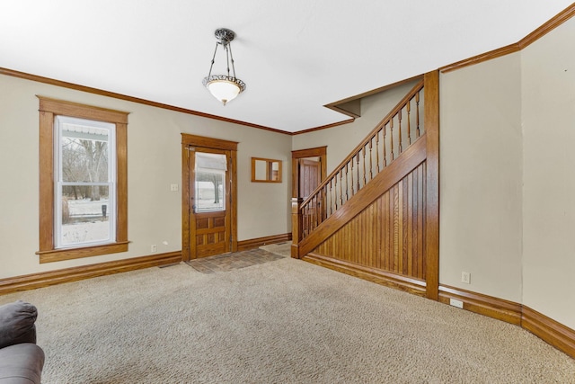 foyer entrance with carpet flooring and ornamental molding