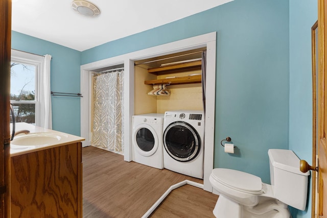 bathroom with vanity, toilet, wood-type flooring, and separate washer and dryer