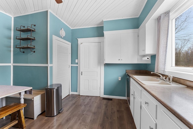 kitchen with dark wood-type flooring, crown molding, sink, dishwasher, and white cabinetry