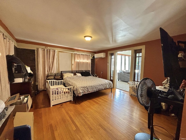 bedroom featuring a wall mounted air conditioner and light wood-type flooring