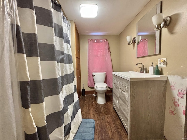 bathroom with toilet, vanity, and hardwood / wood-style flooring