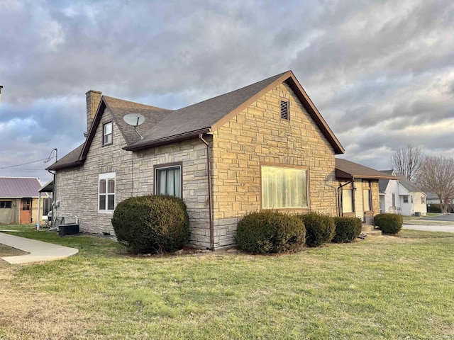 view of property exterior with a yard and central AC unit