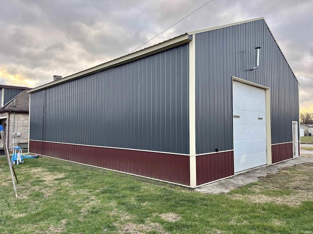 view of outdoor structure with a lawn and a garage