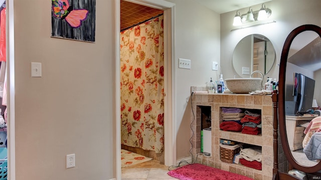 bathroom with tile patterned flooring, vanity, and walk in shower