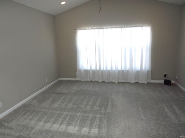 unfurnished room featuring carpet and vaulted ceiling