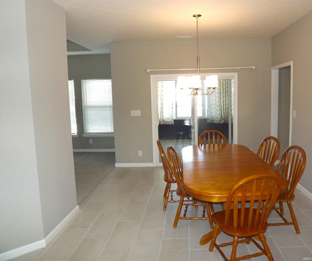 tiled dining area featuring an inviting chandelier