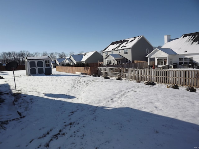 yard covered in snow featuring a storage unit