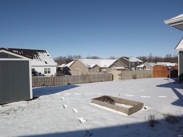 yard layered in snow featuring a storage unit