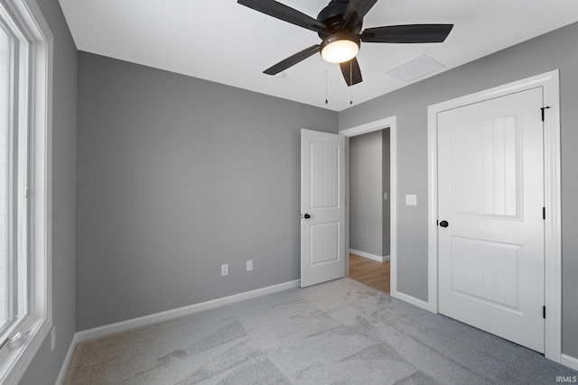 unfurnished bedroom with ceiling fan, a closet, and light carpet