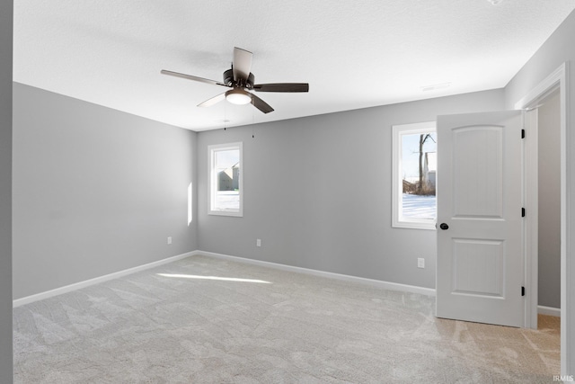 carpeted spare room with a textured ceiling and ceiling fan