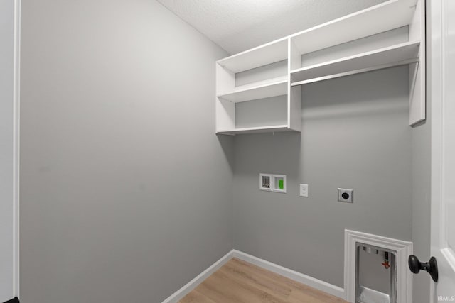 clothes washing area with hookup for an electric dryer, washer hookup, a textured ceiling, and hardwood / wood-style floors
