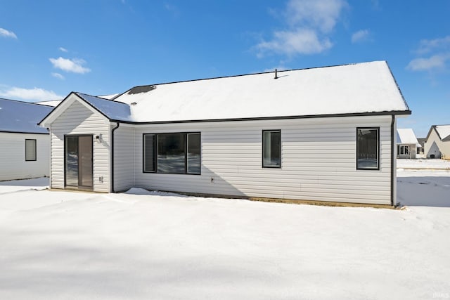 view of snow covered rear of property