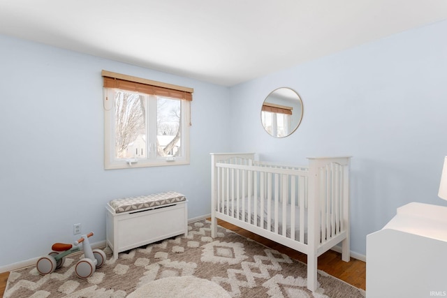 bedroom with a crib and light hardwood / wood-style flooring