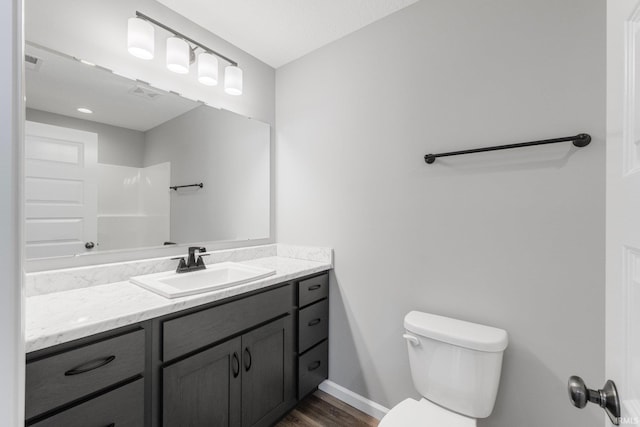 bathroom featuring vanity, toilet, wood-type flooring, and a shower