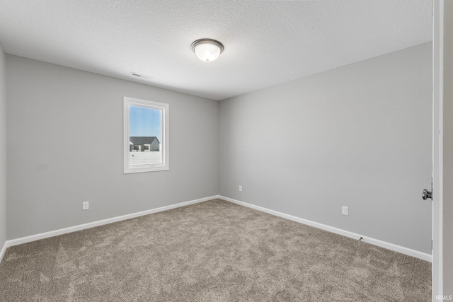 carpeted empty room with a textured ceiling