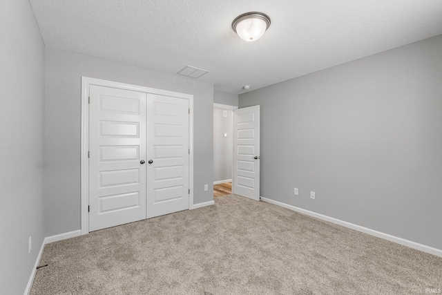 unfurnished bedroom with light colored carpet and a closet