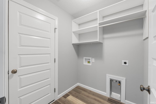 clothes washing area with hookup for an electric dryer, hookup for a washing machine, a textured ceiling, and dark wood-type flooring