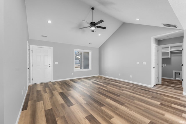 unfurnished living room with dark hardwood / wood-style flooring, vaulted ceiling, and ceiling fan