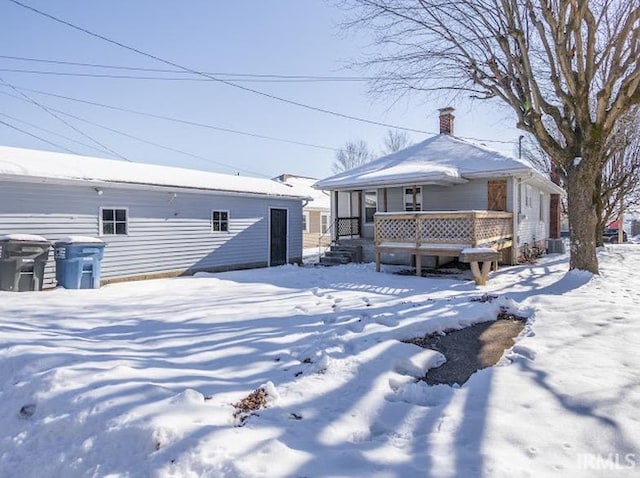 snow covered property with a porch