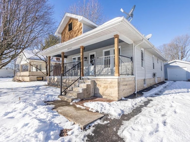 view of front facade featuring covered porch, an outbuilding, and a garage