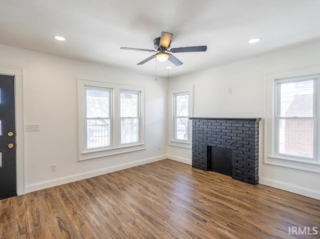 unfurnished living room featuring ceiling fan, dark hardwood / wood-style floors, and a fireplace