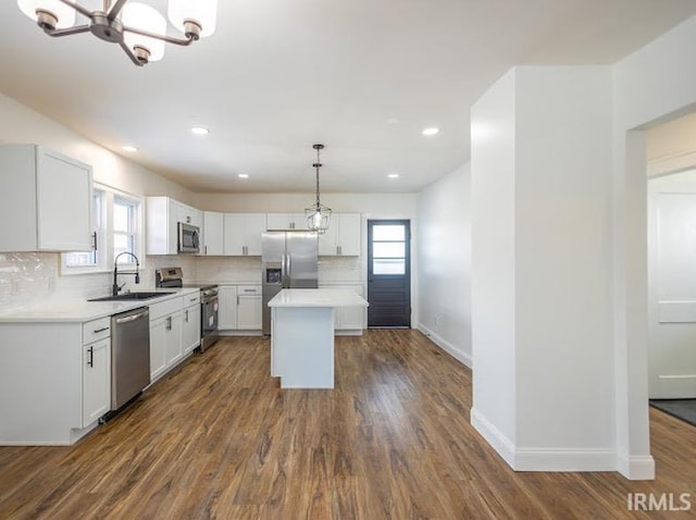 kitchen with white cabinetry, sink, a center island, pendant lighting, and appliances with stainless steel finishes