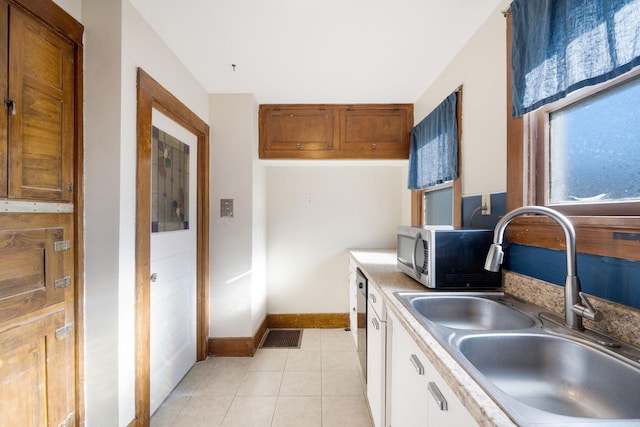 kitchen featuring white cabinets, light tile patterned flooring, and sink