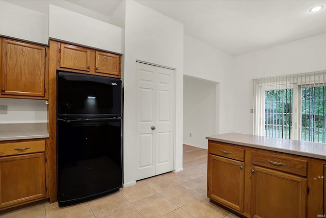 kitchen featuring black refrigerator and light tile patterned floors