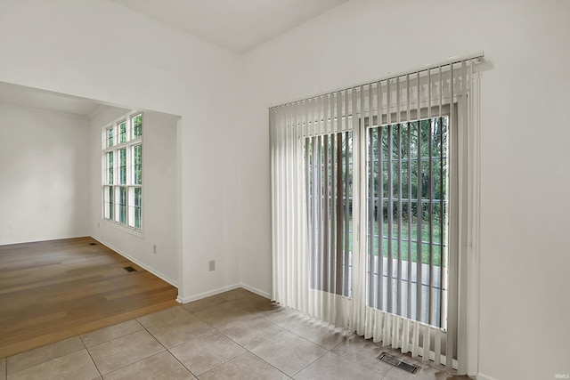 unfurnished room with light tile patterned floors and a wealth of natural light