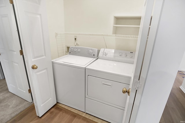 laundry room featuring washer and dryer and wood-type flooring