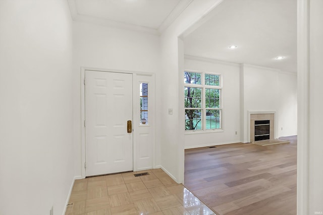 foyer entrance with light hardwood / wood-style flooring and crown molding