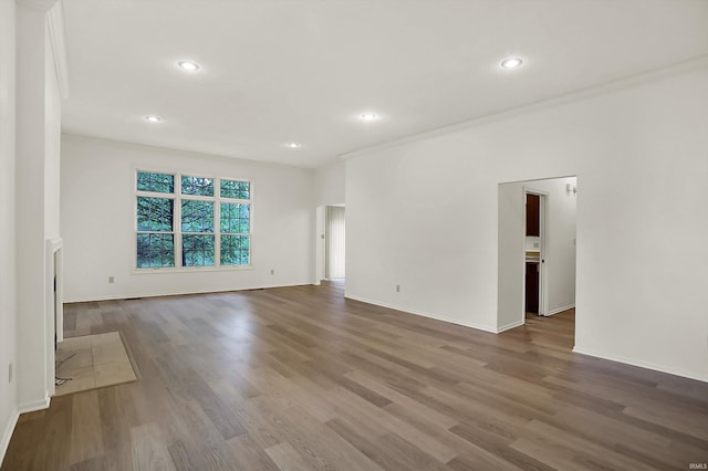 unfurnished living room with hardwood / wood-style flooring and crown molding