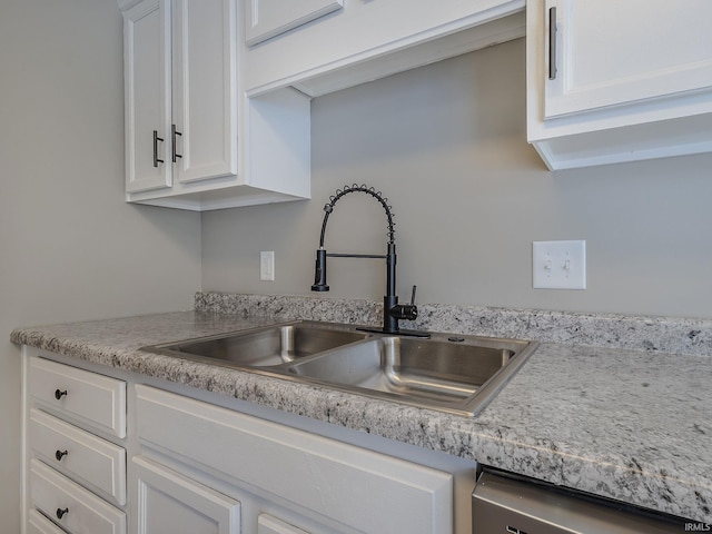 kitchen featuring dishwasher, white cabinetry, and sink