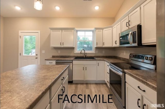 kitchen featuring sink, white cabinets, light wood-type flooring, and appliances with stainless steel finishes