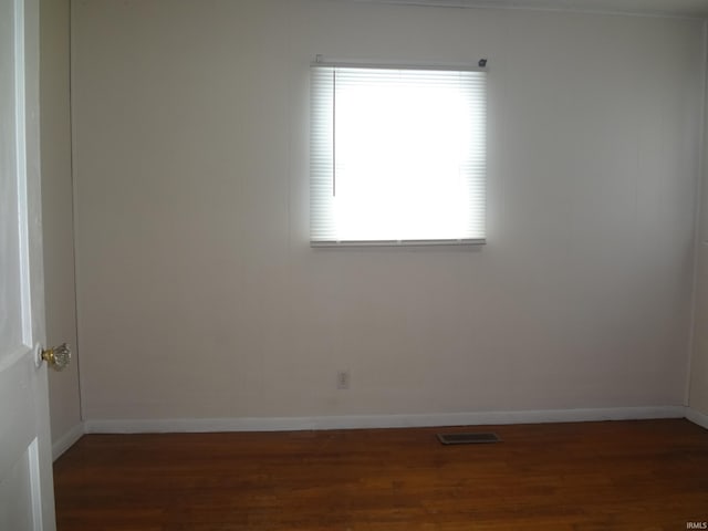 unfurnished room with dark wood-type flooring