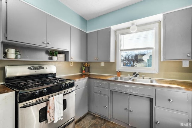 kitchen with gas stove, gray cabinetry, and sink