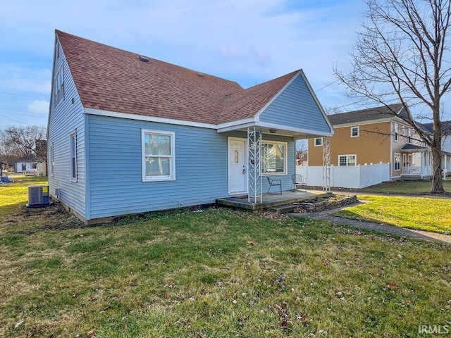 view of front of property with central AC unit and a front lawn